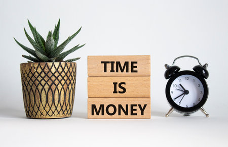 Time is Money symbol. Concept words Time is Money on wooden blocks. Beautiful white background with alarm clock and succulent plant. Business and Time is Money concept. Copy spaceの写真素材