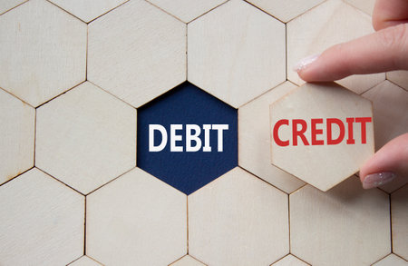 Debit or Credit symbol. Concept word Debit or Credit on wooden comb puzzle. Businessman hand. Beautiful deep blue background. Business and Debit or Credit concept. Copy spaceの写真素材