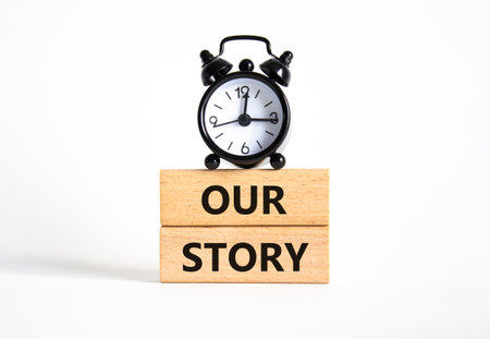 Our story symbol. Wooden blocks with words Our story Beautiful white background with alarm clock. Business and Our story concept. Copy space.の写真素材