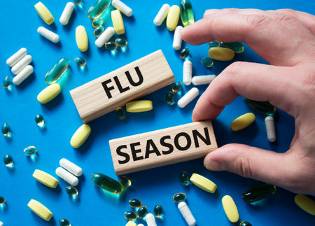Flu Season symbol. Concept word Flu Season on wooden blocks. Beautiful blue background with pills. Doctor Hand. Medicine and Flu Season concept. Copy spaceの写真素材