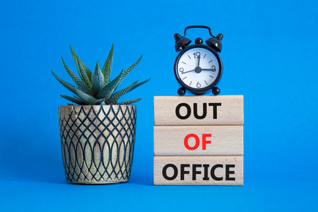 Out of Office symbol. Concept words Out of Office on wooden blocks. Beautiful blue background with succulent plant and alarm clock. Business and Out of Office concept. Copy spaceの写真素材