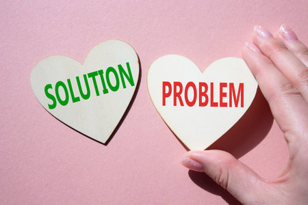 Solution vs Problem symbol. Concept word Solution vs Problem on wooden hearts. Businessman hand. Beautiful pink background. Business and Solution vs Problem concept. Copy spaceの写真素材