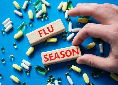 Flu Season symbol. Concept word Flu Season on wooden blocks. Beautiful blue background with pills. Doctor Hand. Medicine and Flu Season concept. Copy spaceの写真素材