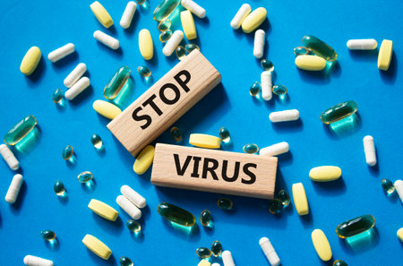 Stop Virus symbol. Concept word Stop Virus on wooden blocks. Beautiful blue background with pills. Medicine and Stop Virus concept. Copy spaceの写真素材