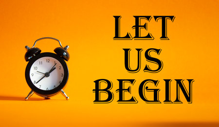 Let us begin symbol. Concept word Let us begin on Beautiful orange background with alarm clock. Business and Let us begin concept. Copy spaceの写真素材