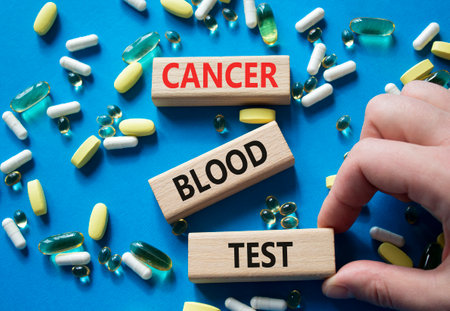 Cancer Blood Test symbol. Concept word Cancer Blood Test on wooden blocks. Doctor Hand. Beautiful blue background with pills. Medicine and Cancer Blood Test concept. Copy spaceの写真素材