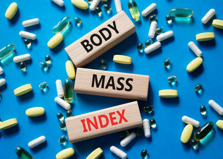 Body Mass Index symbol. Concept word Body Mass Index on wooden blocks. Beautiful blue background with pills. Medicine and Body Mass Index concept. Copy spaceの写真素材