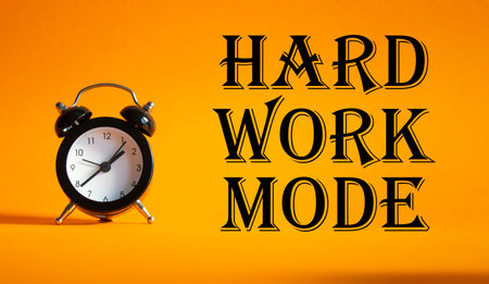 Hard Work Mode symbol. Concept word Hard Work Mode on Beautiful orange background with alarm clock. Business and Hard Work Mode concept. Copy spaceの写真素材