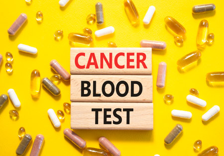 Cancer Blood Test symbol. Concept word Cancer Blood Test on wooden blocks. Beautiful yellow background with pills. Medicine and Cancer Blood Test concept. Copy spaceの写真素材
