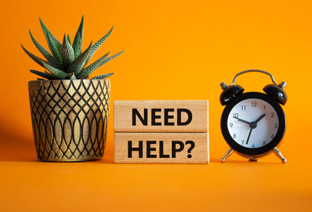 Need Help symbol. Concept words Need Help on wooden blocks. Beautiful orange background with alarm...