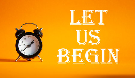 Let us begin symbol. Concept word Let us begin on Beautiful orange background with alarm clock. Business and Let us begin concept. Copy spaceの写真素材