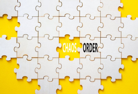 Chaos or Order symbol. Concept word Chaos or Order on wooden puzzle. Beautiful yellow background. Business and Chaos or Order concept. Copy spaceの写真素材