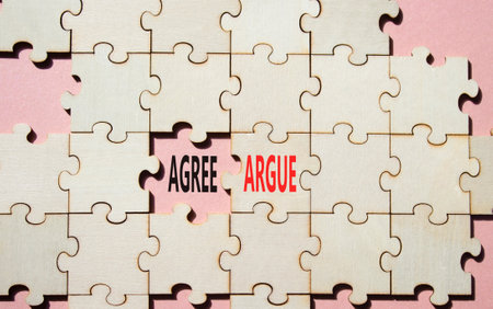 Agree or Argue symbol. Concept word Agree or Argue on wooden puzzle. Beautiful pink background. Business and Agree or Argue concept. Copy spaceの写真素材