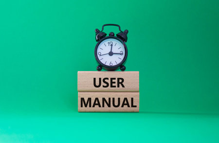 User Manual symbol. Concept words User Manual on wooden blocks. Beautiful green background with...