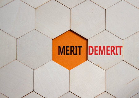 Merit or Demerit symbol. Concept word Merit or Demerit on wooden comb puzzle. Beautiful orange background. Business and Merit or Demerit concept. Copy spaceの写真素材
