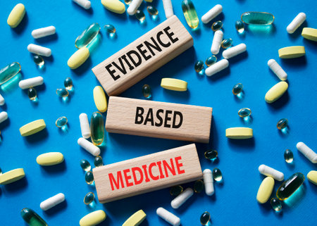 Evidence Based Medicine symbol. Concept word Evidence Based Medicine on wooden blocks. Beautiful blue background with pills. Medicine and Evidence Based Medicine concept. Copy spaceの写真素材