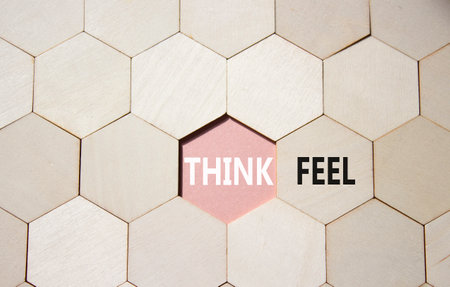 Think or Feel symbol. Concept word Think or Feel on wooden comb puzzle. Beautiful pink background. Business and Think or Feel concept. Copy spaceの写真素材