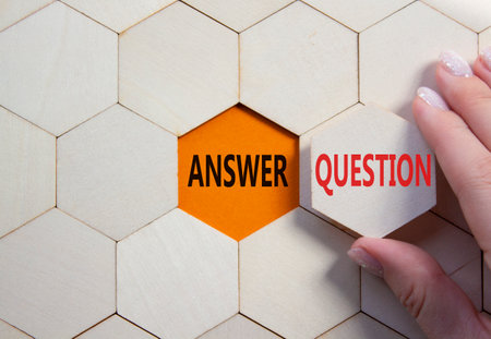 Answer or Question symbol. Concept word Answer or Question on wooden comb puzzle. Beautiful orange background. Business and Answer or Question concept. Copy spaceの写真素材