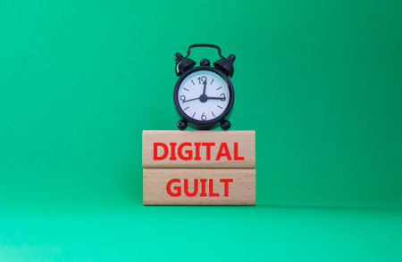 Digital Guilt symbol. Concept words Digital Guilt on wooden blocks. Beautiful green background with alarm clock. Business and Digital Guilt concept. Copy space.の写真素材