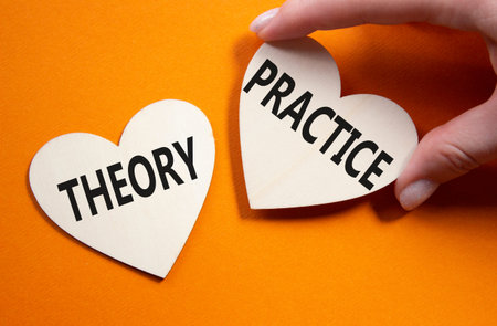 Theory or practice symbol. Concept word Theory or Practice on wooden hearts. Businessman hand. Beautiful orange background. Business and Theory or Practice concept. Copy spaceの写真素材