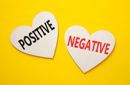 Positive or Negative symbol. Concept word Positive or Negative on wooden hearts. Beautiful yellow...