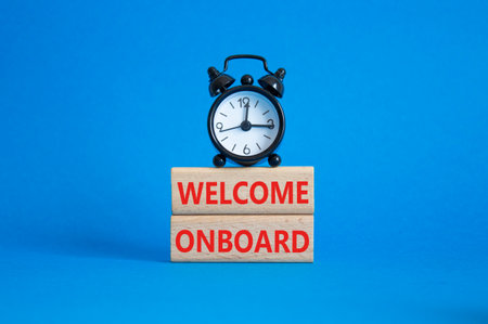 Welcome onboard symbol. Concept words Welcome on board on wooden blocks. Beautiful blue background with alarm clock. Business and Welcome onboard concept. Copy space.の写真素材
