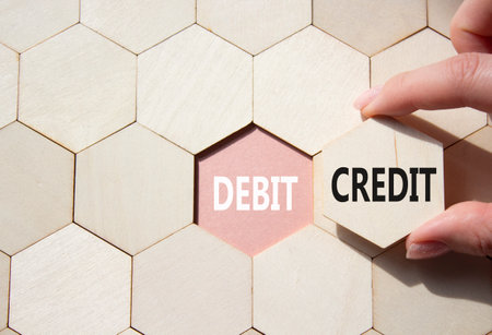 Debit or Credit symbol. Concept word Debit or Credit on wooden comb puzzle. Businessman hand. Beautiful pink background. Business and Debit or Credit concept. Copy spaceの写真素材