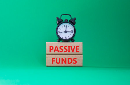 Passive Funds symbol. Concept words Passive Funds on wooden blocks. Beautiful green background with alarm clock. Business and Passive Funds concept. Copy space.の写真素材