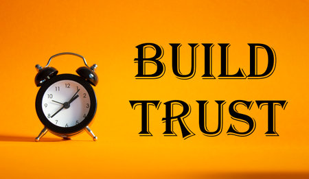 Build trust symbol. Beautiful orange background with alarm clock. Business and Build trust concept. Copy space.の写真素材