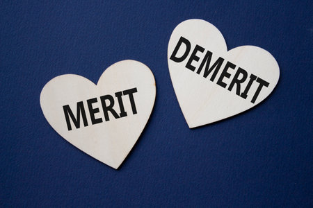Merit or Demerit symbol. Concept word Merit or Demerit on wooden hearts. Beautiful deep blue background. Business and Merit or Demerit concept. Copy spaceの写真素材
