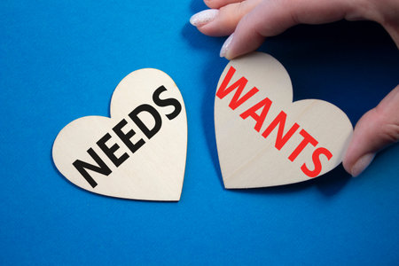 Wants and Needs symbol. Concept word Wants and Needs on wooden hearts. Businessman hand. Beautiful...