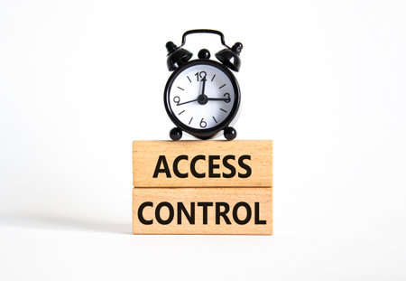 Access Control symbol. Concept words Access Control on wooden blocks. Beautiful white background with alarm clock. Business and Access Control concept. Copy space.の写真素材
