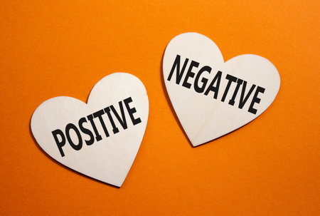 Positive or Negative symbol. Concept word Positive or Negative on wooden hearts. Beautiful orange...