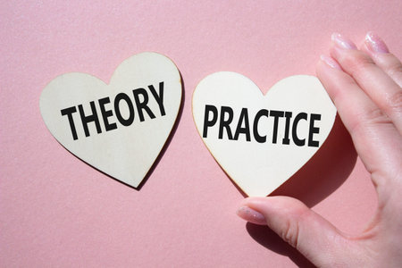 Theory or practice symbol. Concept word Theory or Practice on wooden hearts. Businessman hand. Beautiful pink background. Business and Theory or Practice concept. Copy spaceの写真素材