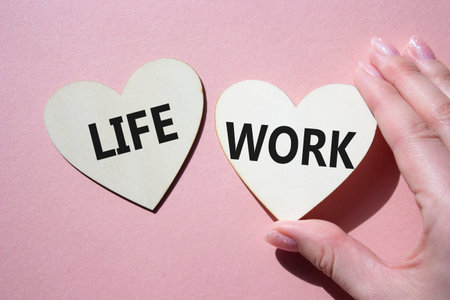 Life or Work symbol. Concept word Life or Work on wooden hearts. Businessman hand. Beautiful pink background. Business and Life or Work concept. Copy spaceの写真素材