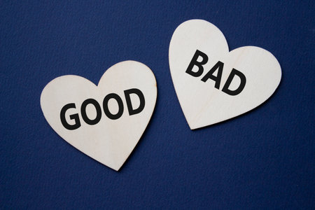 Good or Bad symbol. Concept word Good or Bad on wooden hearts. Beautiful deep blue background. Business and Good or Bad concept. Copy spaceの写真素材