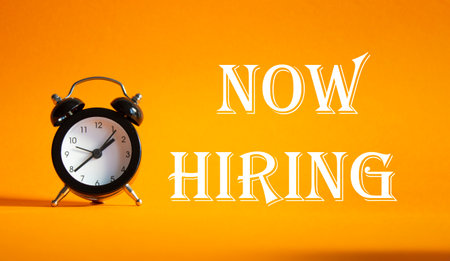 Now Hiring symbol. Concept word Now Hiring on Beautiful orange background with alarm clock. Business and Now Hiring concept. Copy spaceの写真素材