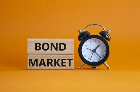 Bond Market symbol. Concept words Bond Market on wooden blocks. Beautiful orange background with alarm clock. Business and Bond Market concept. Copy space.の写真素材