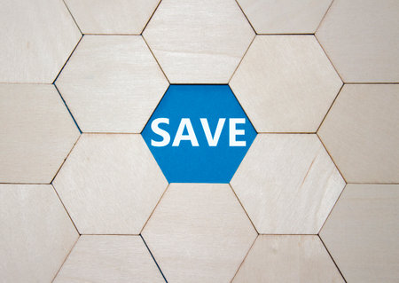 Save symbol. Concept word Save on wooden comb puzzle. Beautiful blue background. Business and Save concept. Copy space.の写真素材