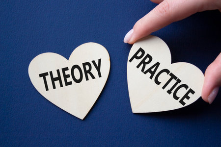Theory or practice symbol. Concept word Theory or Practice on wooden hearts. Businessman hand. Beautiful deep blue background. Business and Theory or Practice concept. Copy spaceの写真素材