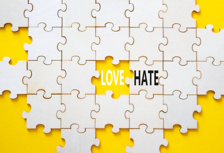 Love vs Hate symbol. Concept word Love vs Hate on wooden puzzle. Beautiful yellow background. Business and Love vs Hate concept. Copy spaceの写真素材