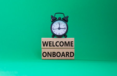 Welcome onboard symbol. Concept words Welcome on board on wooden blocks. Beautiful green background with alarm clock. Business and Welcome onboard concept. Copy space.の写真素材