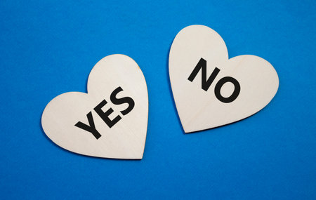 Yes or No symbol. Concept word Yes or No on wooden hearts. Beautiful blue background. Business and Yes or No concept. Copy spaceの写真素材
