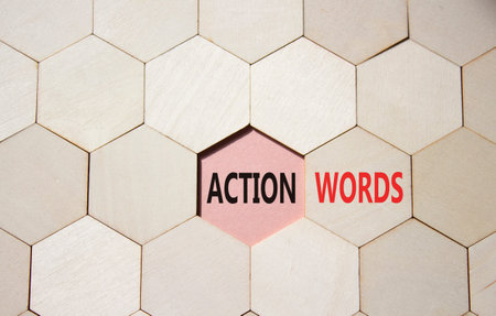 Action or words symbol. Concept word Action or words on wooden comb puzzle. Beautiful pink...