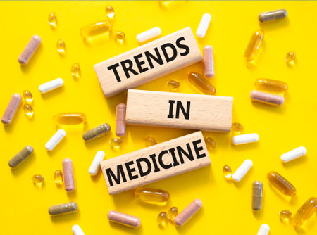 Medicine symbol. Concept words Trends in Medicine on wooden blocks. Beautiful yellow background with pills. Medicine concept and Trends in Medicine. Copy spaceの写真素材