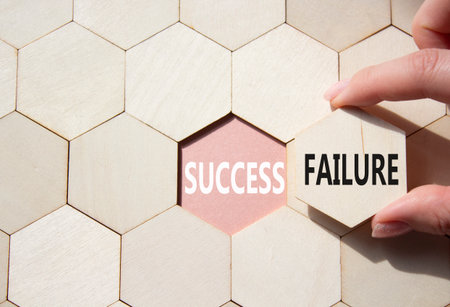 Success or Failure symbol. Concept word Success or Failure on wooden comb puzzle. Businessman hand. Beautiful pink background. Business and Success or Failure concept. Copy spaceの写真素材