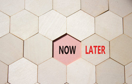 Now vs Later symbol. Concept word Now vs Later on wooden comb puzzle. Beautiful pink background....