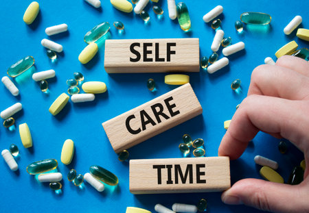 Self-care Time symbol. Concept words Self-care Time on wooden blocks. Beautiful blue background with pills. Doctor hand. Healthcare and Self-care Time concept. Copy space.の写真素材