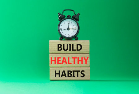 Healthy habits symbol. Concept word Build Healthy habits on wooden blocks with alarm clock. Beautiful green background. Healthy lifestyle and Healthy habits concept. Copy spaceの写真素材