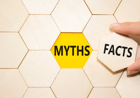Facts or Myths symbol. Concept word Facts or Myths on wooden comb puzzle. Businessman hand. Beautiful yellow background. Business and Facts or Myths concept. Copy spaceの写真素材